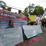 Massa aksi menabur bunga di depan kantor Kejari Jombang sebagai bentuk protes lambannya penegakan hukum. foto: RONY S/ BANGSAONLINE