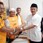 Budi Widayat (berpeci) menerima form pendaftaran dari Farid yang diserahkan H. Fauzan selaku Ketua Tim 13 Hanura.