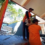 Petugas saat menurunkan beras bantuan. (foto: ist)