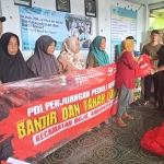 Ketua DPC PDIP Kabupaten Kediri, Murdi Hantoro, saat menyerah bantuan secara simbolis kepada salah satu warga. Foto: MUJI HARJITA/ BANGSAONLINE