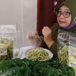 Cholifatul Roifah saat mengemas stik daun kelor dalam plastik. foto: MUJI HARJITA/ BANGSAONLINE