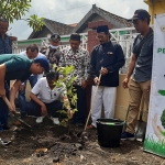 Syaikhul Islam menanam pohon kelengkeng di halaman Kantor Desa Gedangrowo Kecamatan Prambon, Minggu (14/8/2022). foto: Mustain/BANGSAONLINE