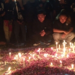 Doa bersama di Stadion Wilis Madiun diwarnai tabur bunga dan nyala lilin. Foto: HENDRO SUHARTONO/ BANGSAONLINE