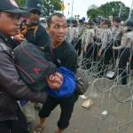 TIGA HARI DEMO: Seorang guru honorer pingsan dan diangkat rekan-rekanya untuk mendapat penanganan kesehatan saat aksi unjuk rasa di depan Istana Merdeka. foto: merdeka.com