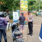 Sejumlah personel Polres Batu melakukan pengetatan penerapan protokol kesehatan di lokasi wisata.