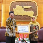 Gubernur Khofifah saat menerima piagam penghargaan dari Pimpinan Pusat Ombudsman RI, Johannes Widijantoro, di Gedung Negara Grahadi, Surabaya.