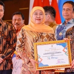Bupati Mojokerto ketika menerima penghargaan untuk program Rutilahu dari Gubernur Khofifah.