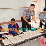 Kalapas Klas IIA Kediri, Urip Dharma Yoga, saat menunjukkan tempe hasil produksi para WBP Lapas Kediri. Foto: Muji Harjita/BANGSAONLINE