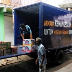 ANGKUT: Bantuan yang digalang NasDem Sidoarjo mulai dinaikkan ke truk, Kamis (3/1). foto ist