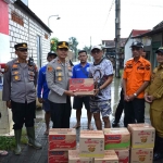 Kapolres Gresik saat menyerahkan bantuan kepada Kades Balurejo untuk korban terdampak banjir. Foto: Ist