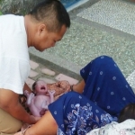 HEROIK: Chusana, Kepala Desa Pasirharjo saat membantu seorang ibu melahirkan di pinggir jalan.