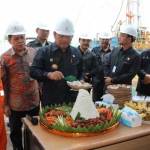 TASYAKURAN: Bupati Sidoarjo H Saiful Ilah memotong tumpeng saat Lapindo memulai workover sumur Wunut 4, di Desa Wunut, Kecamatan Porong, Sidoarjo, Senin (8/8). foto: istimewa