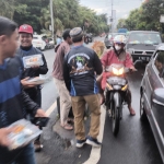 Para Anggota Aspek Kota Batu saat membagikan takjil kepada para pengguna jalan yang melintas di sekitar Balai Kota Batu. foto: ADI WIYONO/ BANGSAONLINE