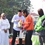 Bupati Subandi menyerahkan bantuan beras ke pengemudi Ojol saat acara Doa Bersama, Jumat (5/9/2025). (Ist)