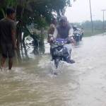 HAJAR, SIST: Seorang pengendara nekat melintasi genangan air saat banjir yang terjadi belum lama ini. foto: eki nurhadi/ BANGSAONLINE