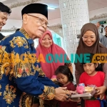 Alie Sadikin, Tenaga Ahli Advokasi TPPS Setwapres (kanan) bersama Ketua Ponpes Wali Barokah, KH Sunarto, saat memberikan makanan bergizi kepada salah satu santri. Foto: MUJI HARJITA/BANGSAONLINE.