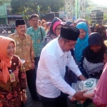 MURAH: Bupati Sidoarjo H Saiful Ilah menyerahkan sembako kepada warga saat membuka Pasar Rakyat dan Bazar Ramadan, di GOR Delta, Jumat (16/6). foto: MUSTAIN/ BANGSAONLINE