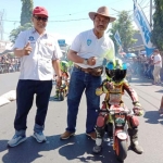 Muhammad Alwi dengan Ketua Impas Pamekasan Sabto Wahyono saat berselfie dengan pembalap cilik Pamekasan.