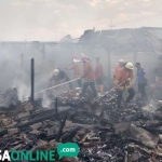 Petugas PMK saat melakukan pembasahan pada puing-puing pasar Sukodadi.