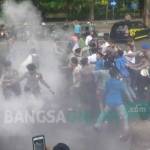 RICUH: Dua polisi tampak melakukan penyemprotan asap kepada ketua PMII Bojonegoro, Ahmad Syahid. foto: eky nurhadi/ BANGSAONLINE