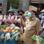 Bupati Sambari bersama para pejabat dan ASN dengan latar berbagai sayuran, buah-buahan, dan aneka makanan kampung dalam perayaan maulid Nabi Muhammad SAW. foto: ist.