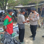 Petugas gabungan saat membagikan masker dalam giat pamor keris, Rabu (9/2).