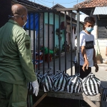 Salah satu anggota linmas saat ikut mengantarkan bantuan sembako kepada warga yang sedang menjalani isolasi mandiri. foto: ist.