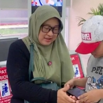 Rini saat mendampingi putranya menjalani terapi okupasi dan wicara secara rutin di rumah sakit.