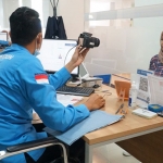Petugas Kantor Imigrasi Kediri saat melayani salah seorang warga yang ingin mengurus paspor. Foto: Ist