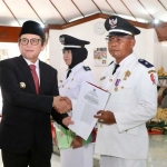 Ketua AKD Kabupaten Bojonegoro Sudawam (kanan) menerima SK perpanjangan masa jabatan kades dari Pj Bupati Bojonegoro Adriyanto (kiri) di Pendapa Pendapa Malowopati Bojonegoro, Senin (10/6/2024). Foto: Dok. Humas Pemkab Bojonegoro