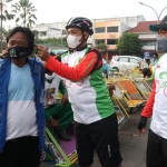 Dewan saat memakaikan masker ke salah satu abang becak dalam kegiatan gowes.