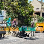 Para pekerja saat mengerjakan penambalan jalan berlubang di wilayah Kecamatan Ngasem. Foto: MUJI HARJITA/BANGSAONLINE