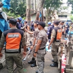 Tim Gabungan Satpol PP, TNI, dan Polri saat menertibkan warung di Jalan Diponegoro, Klojen, Kota Malang, Rabu (26/02). foto: IWAN IRAWAN/ BANGSAONLINE