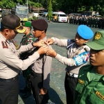 Kapolres Pasuruan AKBP Raydian Kokrosono, SIK, menyematkan pita tanda berjalannya pengamanan pemilukada serentak di halaman Mapolres Pasuruan. Foto: ANDY FACHRUDIN/BANGSAONLINE