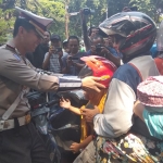 Kasatlantas Polresta Sidoarjo Kompol Fahrian Saleh Siregar saat membagikan helm kepada penumpang anak-anak.