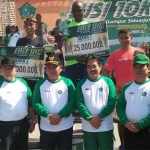 James Gikunga Karansa, pelari asal Kenya yang menjadi juara 1 lomba lari Lusi foto bersama Bupati Sidoarjo H. Saiful Ilah, S.H, M.Hum usai menerima hadiah .
