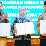 Gubernur Jawa Timur, Khofifah Indar Parawanas, Ketua KPU dan Ketua Bawaslu Jatim menunjukkan nakah penandatanganan Naskah Perjanjian Hibah Daerah (NPHD) untuk pelakanaan Pilgub 2024. 