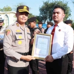 Kapolres Gresik AKBP Rovan Richard Mahenu (kiri) saat memberikan penghargaan kepada personel berprestasi. Foto: Ist
