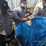 Petugas saat mengevakuasi mayat perempuan tanpa identitas.