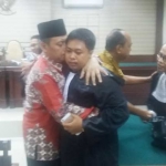 Husnul Khuluq memeluk penasehat hukumnya, Hadi Mulyo Utomo usai majelis hakim membebaskan dirinya dari dakwaan penuntut umum. foto: DIDI ROSADI/ BANGSAONLINE