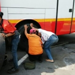 Sopir bus mengganti ban belakang.  foto : rony suhartomo 