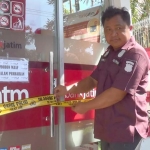 Petugas saat memasang garis polisi di ATM Bank Jatim yang dibobol.