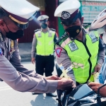 Seorang pengendara mendapat tanda janur kuning di sepeda motornya karena melanggar lalu lintas.