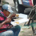 Para tukang becak saat menyantap hidangan nasi kotak dari Pemkab Trenggalek yang dimasak di dapur umum. foto: HERMAN/ BANGSAONLINE