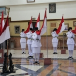 12 anggota paskibraka mencium bendera merah putih saat pengukuhan di Balai Kota Surabaya. 