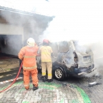 Petugas Damkar Surabaya saat melakukan pembasahan usai memadamkan api dari mobil Kijang LGX di Sukolilo