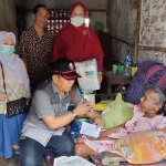 Koordinator Laskar Kediri Bisa, Sutrisno saat menyerahkan bantuan kepada Mbah Lasemi didampingi Widia, Koordinator PDKK (Perkumpulan Disabilitas Kabupaten Kediri) Kecamatan Puncu. Foto: Muji Harjita/ BANGSAONLINE.com 