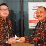 Pj Wali Kota Mojokerto, Moh Ali Kuncoro, saat memberi penghargaan kepada Kepala Dinsos P3A Kota Mojokerto, Choirul Anwar.