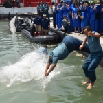 Tradisi cebur laut usai kenaikan pangkat di Koarmatim. foto: Dispen Armatim 