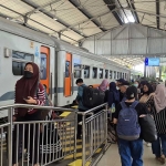 Suasana naik turun penumpang di stasiun kereta api.